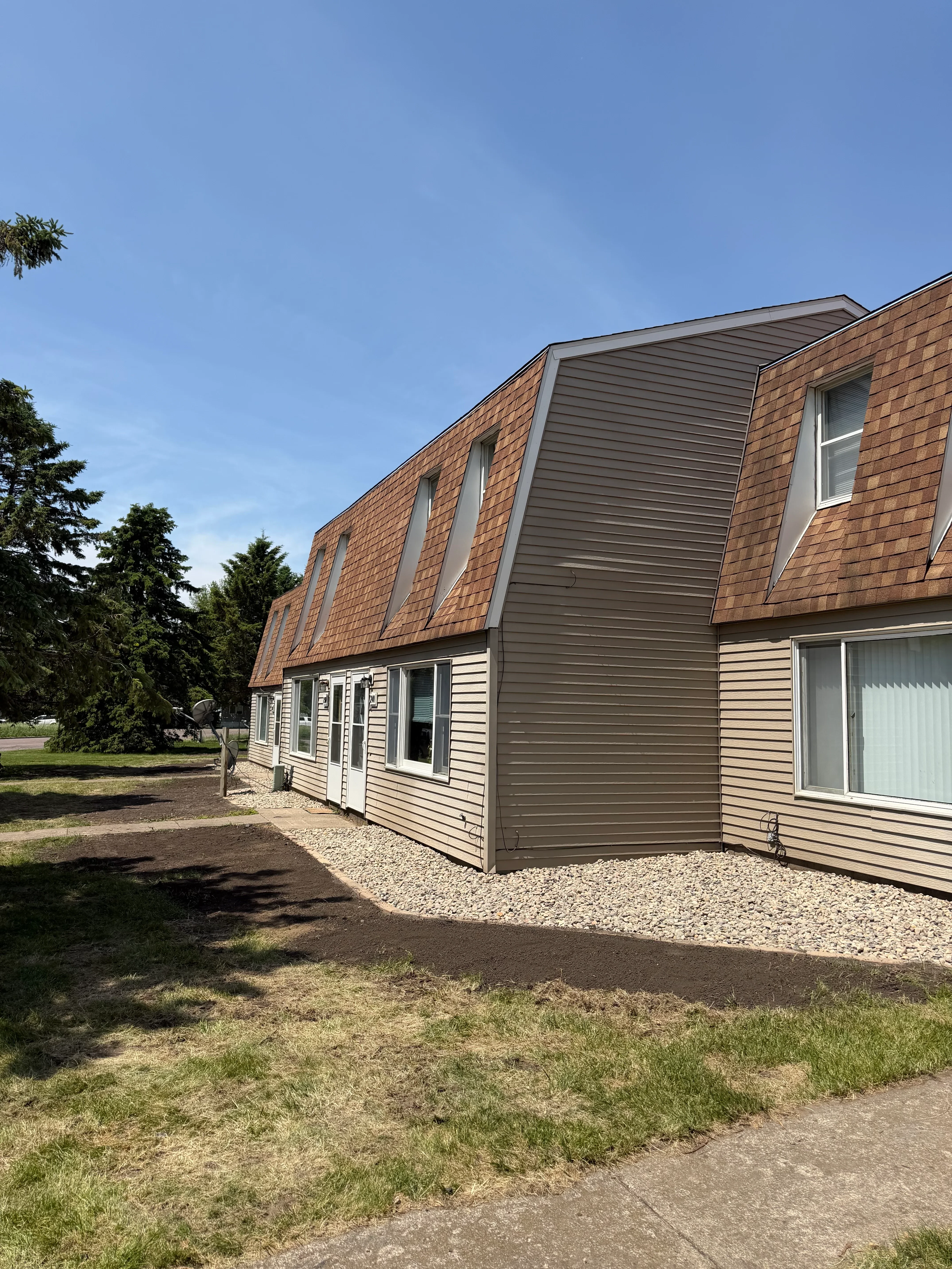 Residential property with maintained lawn, concrete driveway, and brick home exterior